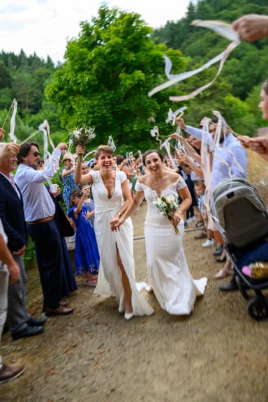 Vita et Charlotte sortent de cérémonie sous une haie de rubans